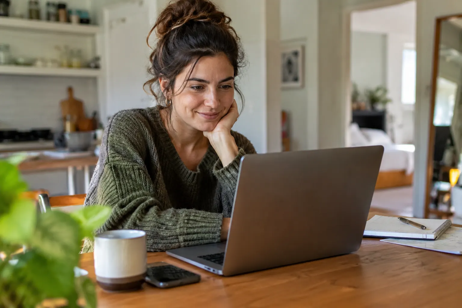 Femme consultant son ordinateur portable à la maison